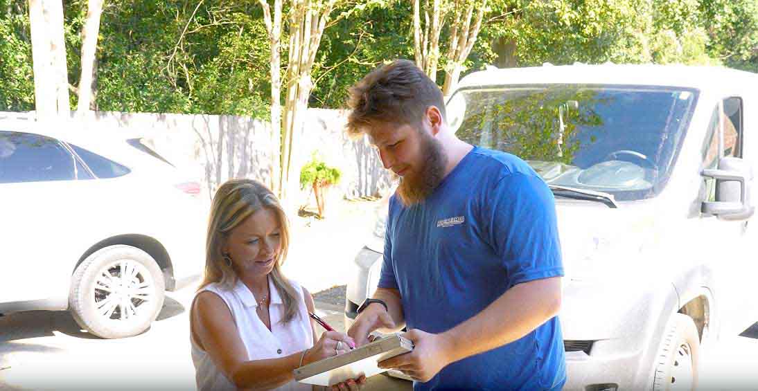 Rooter Pros technician going over the flat-rate quote with a homeowner